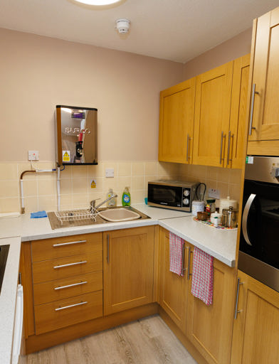 Kitchen area with oven, tabletop hob, cupboards and preparation areas 