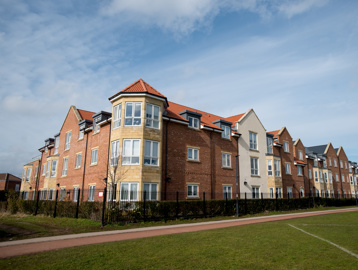 Grassed area and railing alongside the building of Meadowfields