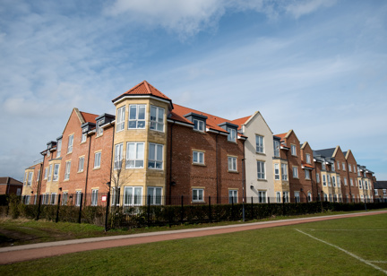 Grassed area and railing alongside the building of Meadowfields