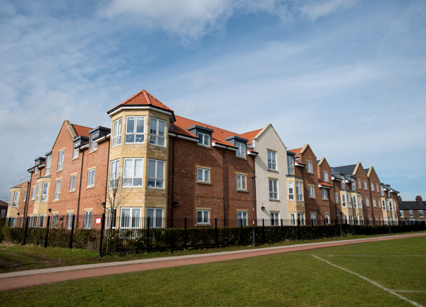 Grassed area and railing alongside the building of Meadowfields