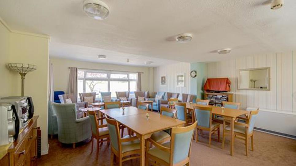 Communal dining area with tables and chairs around the room