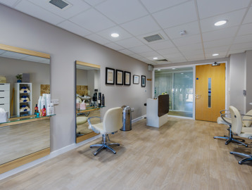 Inside the hair salon at Oakwood Gardens. Featuring large mirrors, chairs and sinks