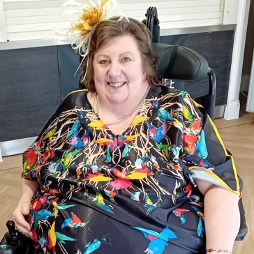 Resident in colourful dress sat in a wheelchair