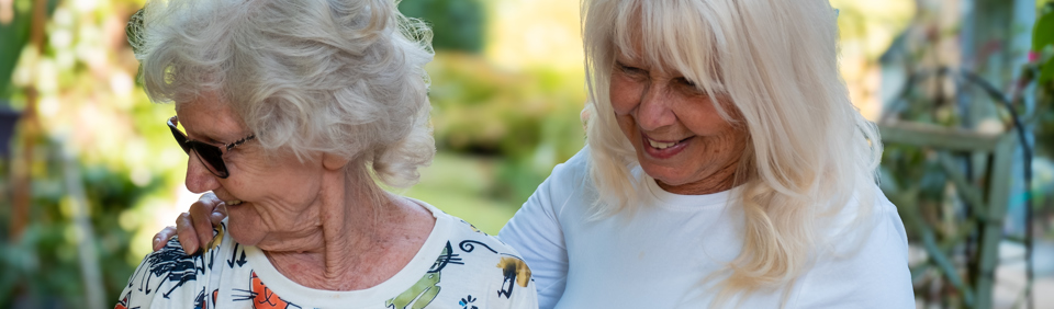 A mother and daughter enjoying the communal gardens at St Crispin 