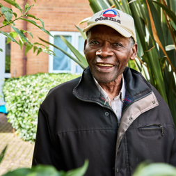 Resident smiling in a garden 