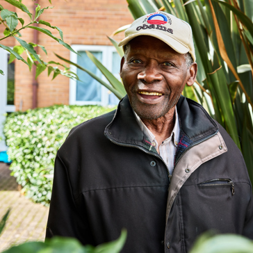 Resident smiling in a garden 