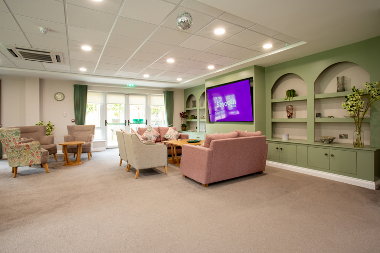 Lounge area at Dovecote Meadow with sofas and TV.