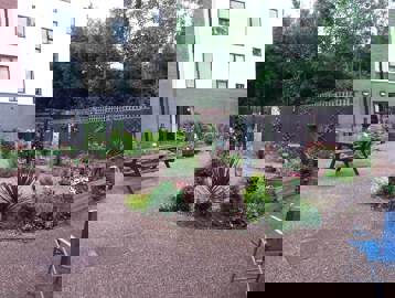 Hard-landscaped communal garden with benches, plants and flowers