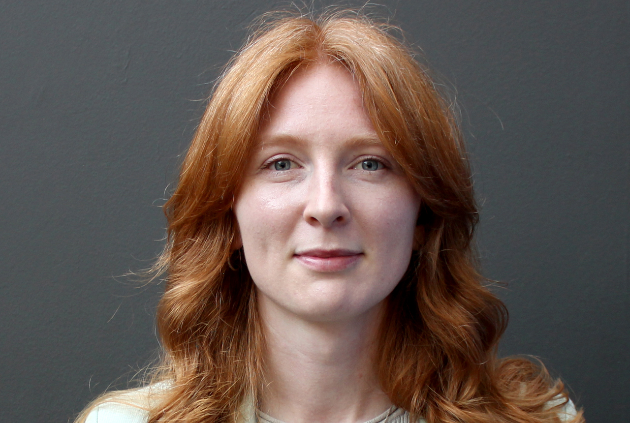 A red headed lady stares into the camera