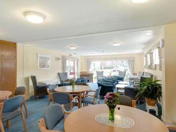 Communal lounge area with chairs and tables and a selection of books
