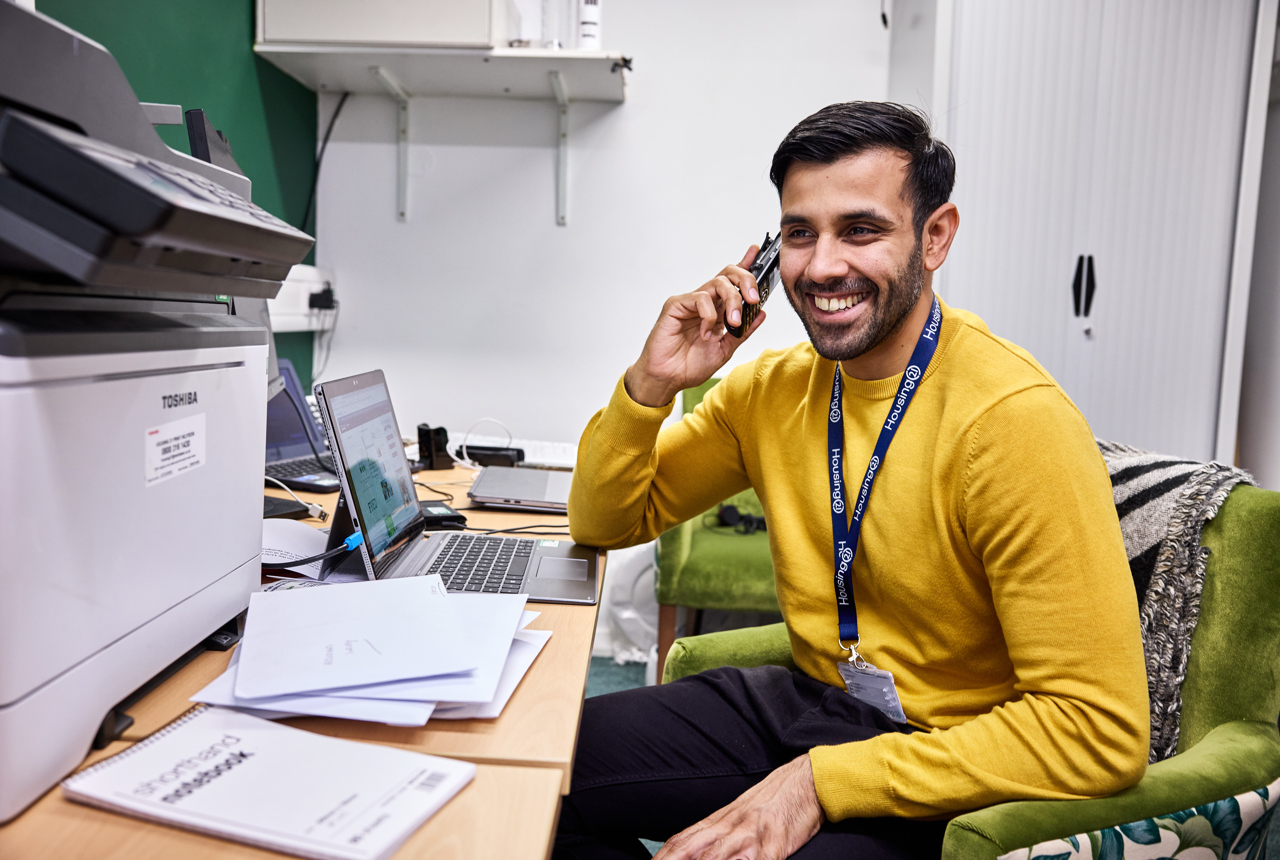 Employee sitting down smiling on a phone call 