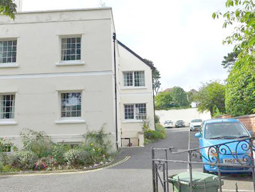 A sideview of the outside of the scheme with cars parked alongside