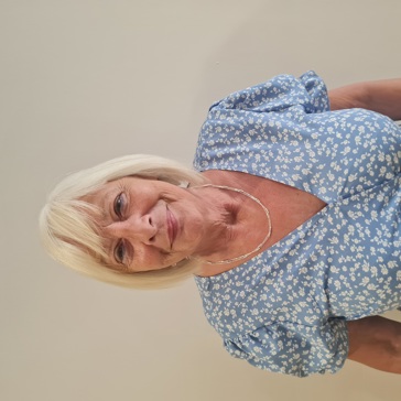 A close-up headshot of a female resident in a blue and white flowery dress