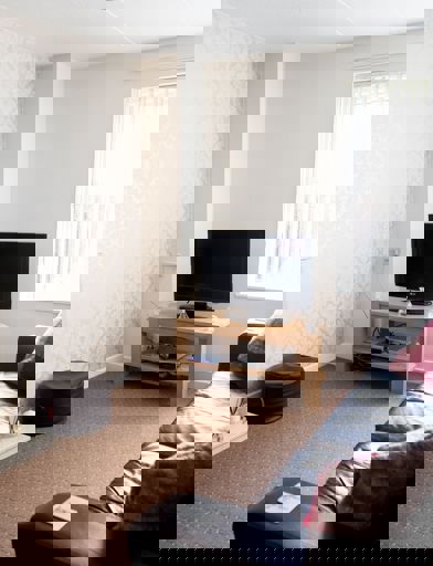 Lounge in a residents' home with sofa, TV and electric fireplace