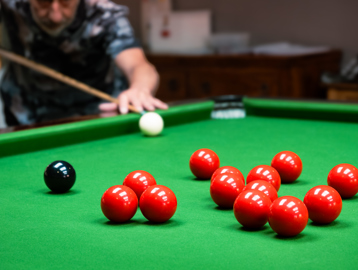 A resident enjoying a game of snooker in the snooker room