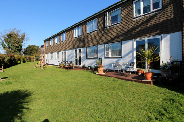 Communal gardens with plants and seating on a large grassed area