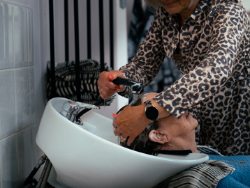A resident having her hair washed in the on-site hair salon