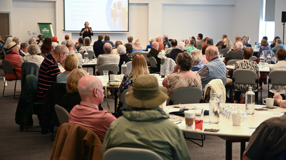 A crowd shot of the resident conference with groups of people at different tables