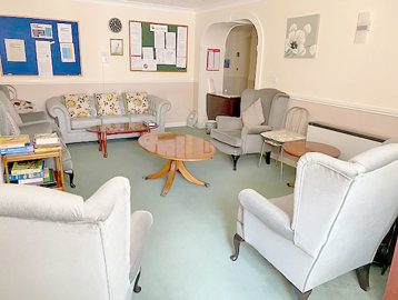 Small communal lounge area with seating, coffee tables and a selection of books