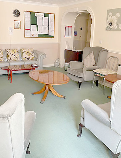 Small communal lounge area with seating, coffee tables and a selection of books 