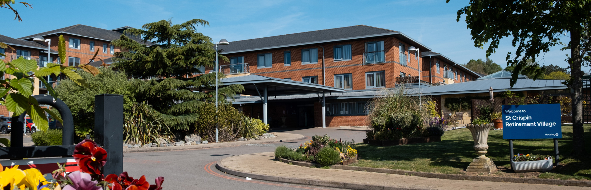 Main entrance to St Crispin Village with large Housing 21 sign