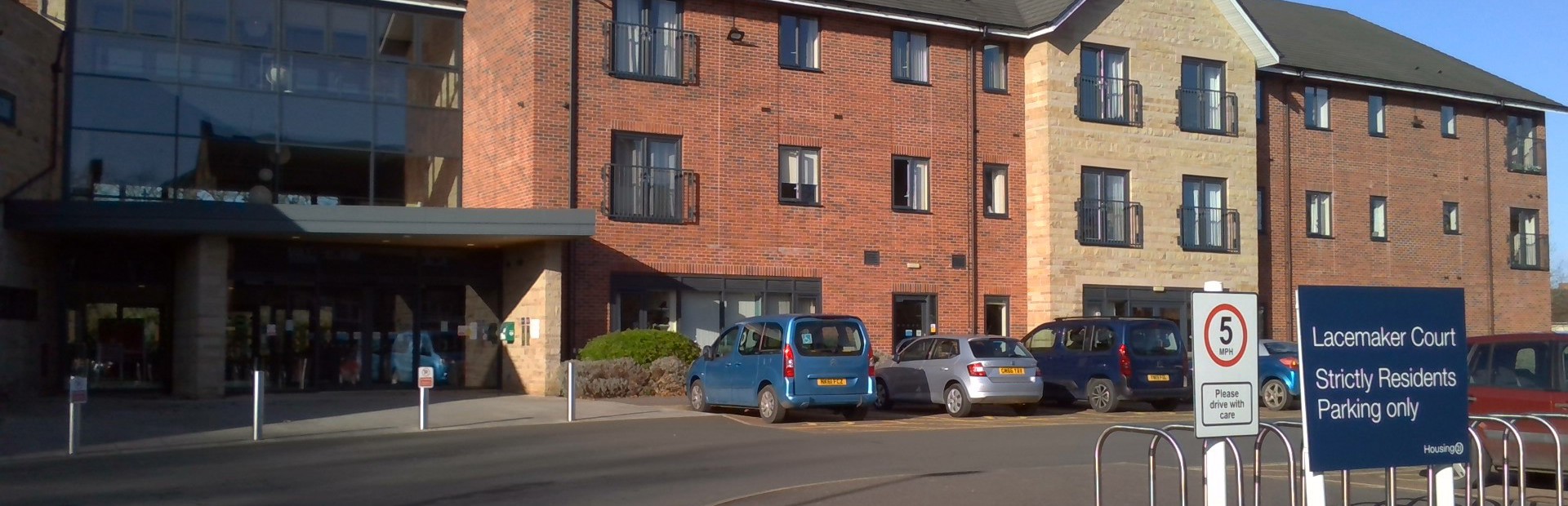 Front entrance of the building to Lacemaker Court with large parking area