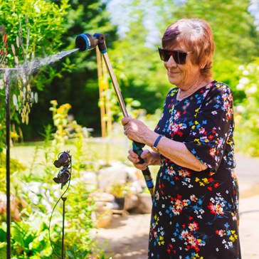 Resident watering plants in a garden