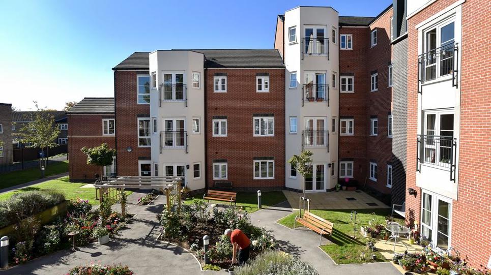 Photo of a large communal garden area with plants, flowers and seating areas