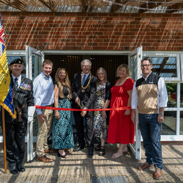 Housing 21 employees are joined by the Chairman of Sprowston Town Council and the standard bearer for the Catton Branch of the Royal British Legion to cut the ribbon Redmayne View following a makeover