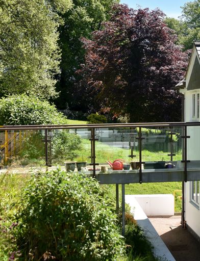 Garden and walkway to the back of the apartments on a sunny day 
